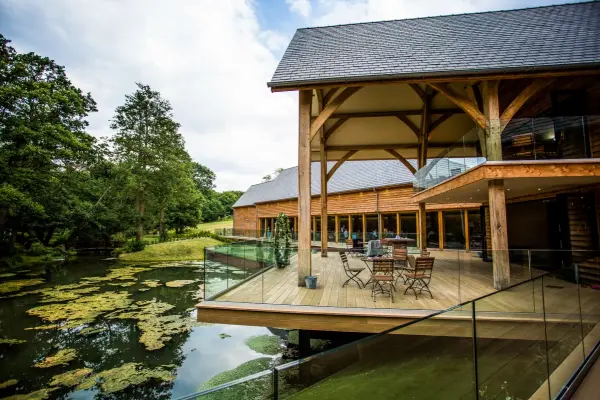 Spacious outdoor deck overlooking a serene pond, featuring rustic wooden architecture and cozy seating for intimate gatherings.