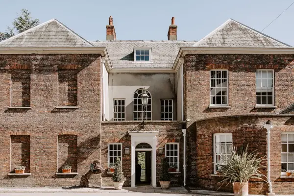 Charming brick mansion featuring large windows and elegant entryway, perfect for intimate wedding ceremonies or receptions.