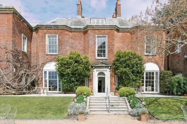 Elegant red brick venue with manicured gardens, lush greenery, and inviting entry steps, perfect for a charming wedding celebration.