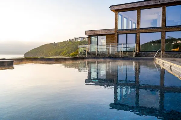 Elegant venue featuring a stunning infinity pool reflecting a contemporary building, with rolling hills in the background for picturesque views.
