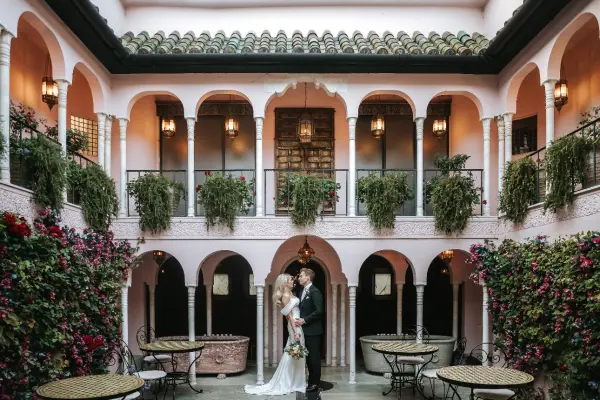 Romantic courtyard featuring lush greenery, intricate arches, and vintage tables, perfect for intimate wedding ceremonies and receptions.