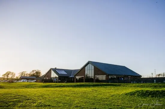 Spacious wedding venue featuring modern architecture, large windows, and scenic green surroundings, perfect for outdoor ceremonies.