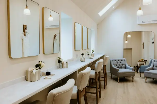 Bright bridal suite featuring elegant mirrors, cozy seating, and a chic design, perfect for pre-wedding preparations.