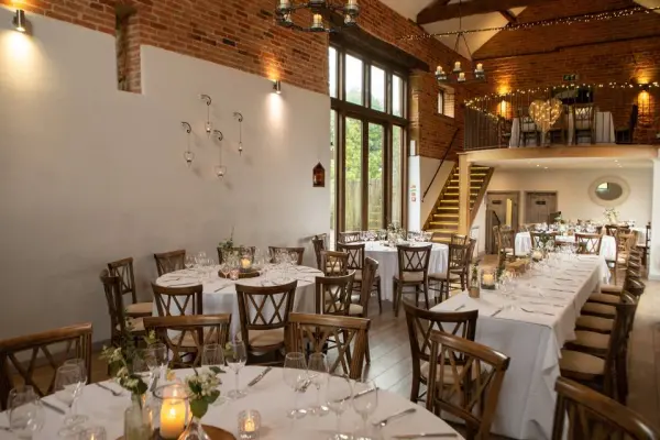 Charming rustic venue with exposed brick walls, elegant wooden chairs, and soft lighting, perfect for intimate wedding receptions.