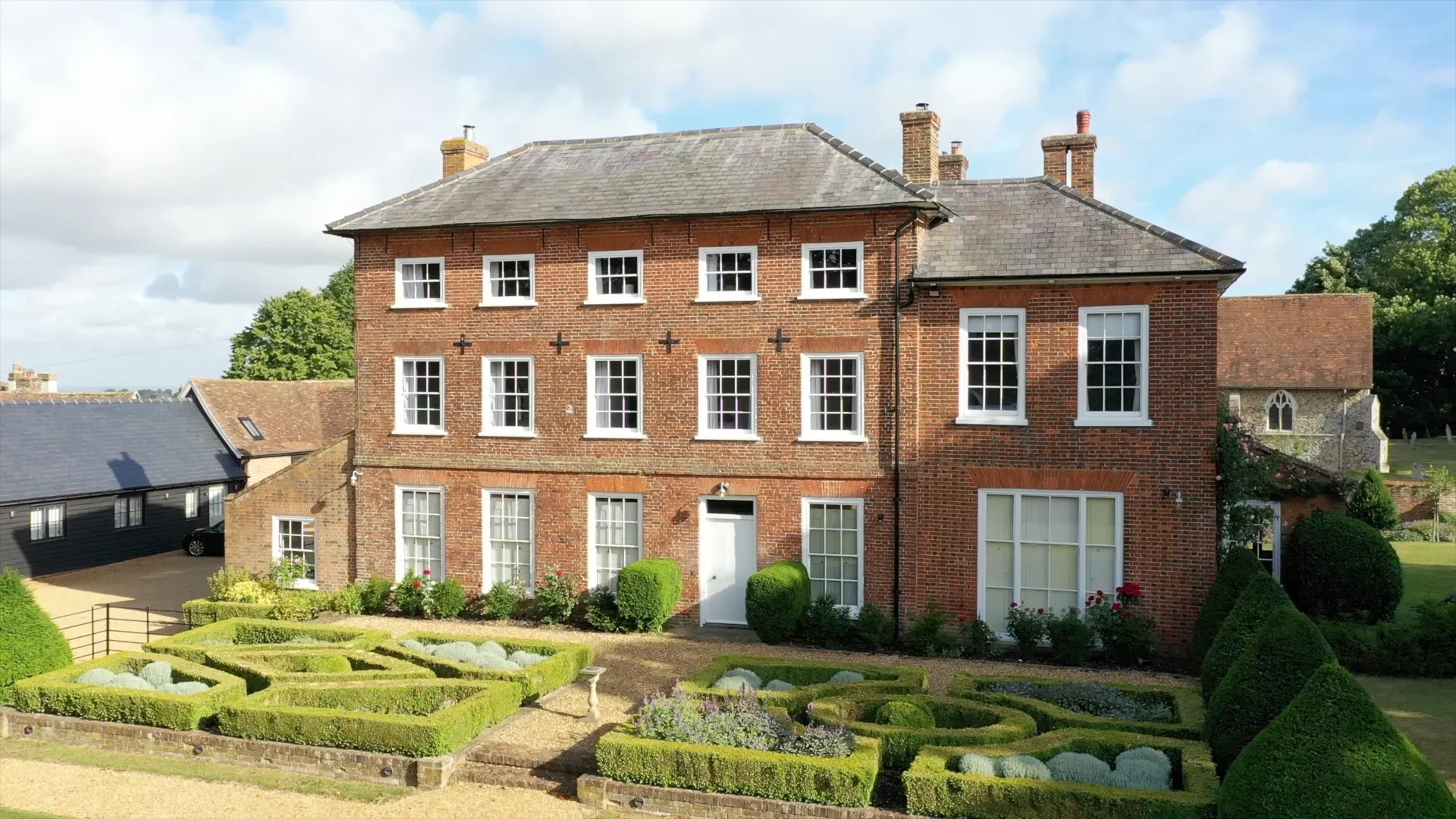 Historic brick manor with landscaped gardens, lush greenery, and charming outdoor spaces, perfect for elegant wedding ceremonies and receptions.