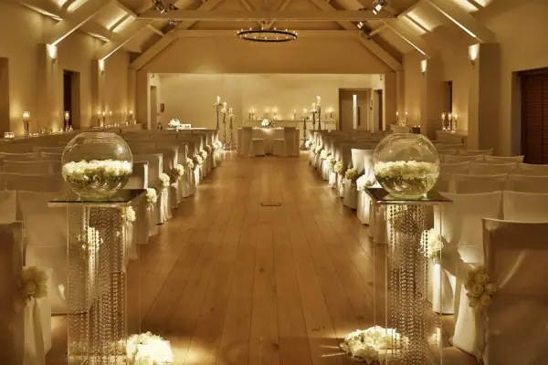 Elegant ceremony space featuring soft lighting, decorated seating, and floral centerpieces creating a romantic ambiance.