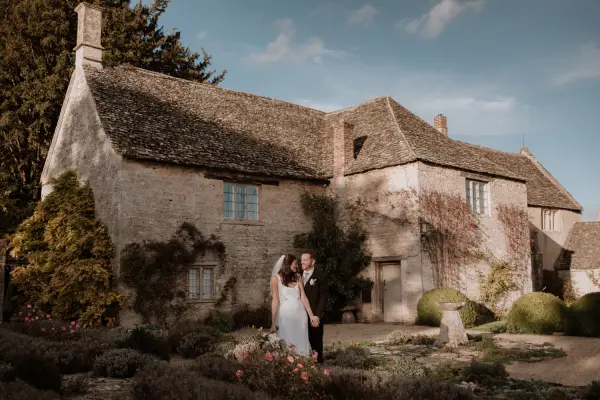 Charming stone cottage surrounded by lush gardens, perfect for intimate weddings and outdoor ceremonies. Romantic couple in focus.