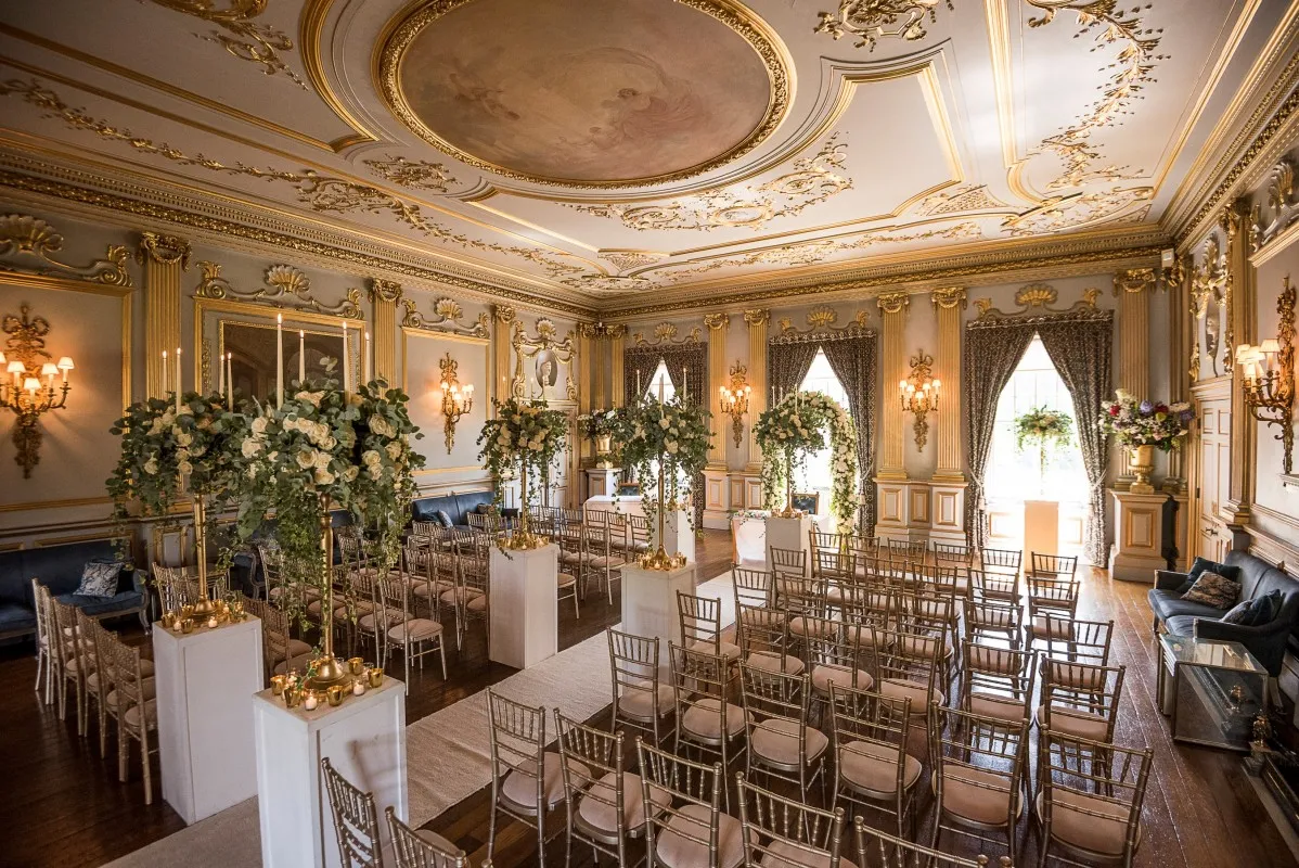 Ornate ballroom featuring luxurious decor, elegant seating, and floral arrangements, perfect for a sophisticated wedding ceremony.
