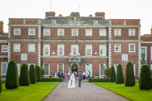 Charming red brick mansion with manicured gardens, perfect for elegant outdoor ceremonies and sophisticated receptions.