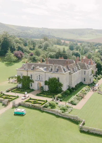 Aerial view of an elegant estate featuring manicured gardens, lush lawns, and classic architecture, perfect for outdoor ceremonies.