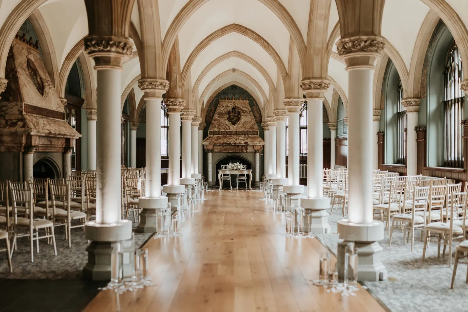 Elegant ceremony space featuring tall vaulted ceilings, intricate arches, and rows of chiavari chairs, creating a romantic atmosphere.