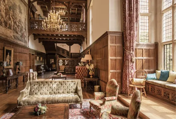 Elegant wood-paneled lounge with a grand chandelier, plush seating, and intricate details, creating a warm, inviting atmosphere for weddings.