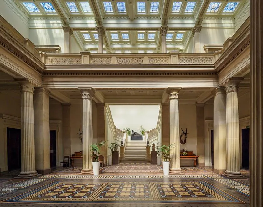 Grand entrance hall featuring elegant columns, intricate flooring, and abundant natural light from skylights, perfect for a timeless wedding.