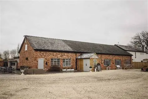 Charming rustic barn with warm brick exterior, large windows, and a welcoming entrance, perfect for intimate wedding celebrations.